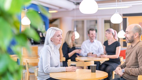 medarbejdere, der får en kop kaffe og griner